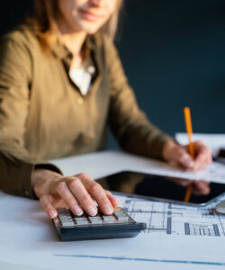 Persona realizando cálculos fiscales y revisando documentos para evitar problemas con Hacienda por no justificar adecuadamente las deducciones."